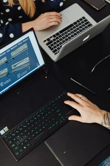 A laptop on a bed showing web design software, creating a cozy workspace.